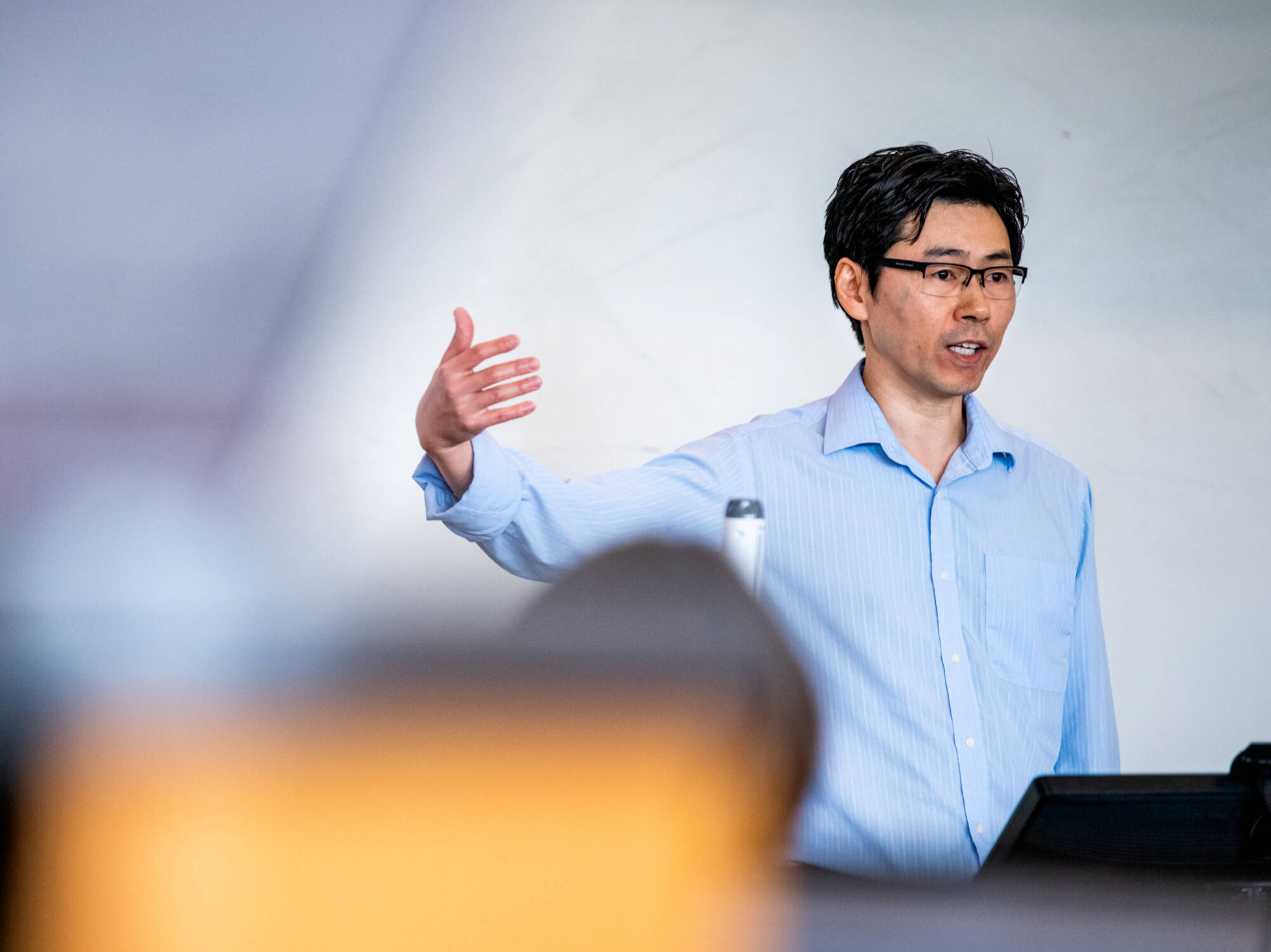 Associate professor Laudo Ogura teaching in front of a whiteboard